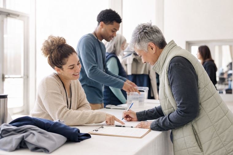 Persona che regge un cartello scritto a mano, come al banchetto del tesseramento